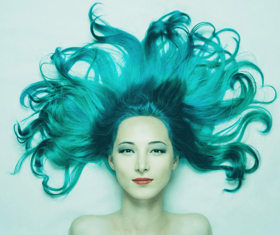 emme aux cheveux turquoise flottants dans l'eau de piscine