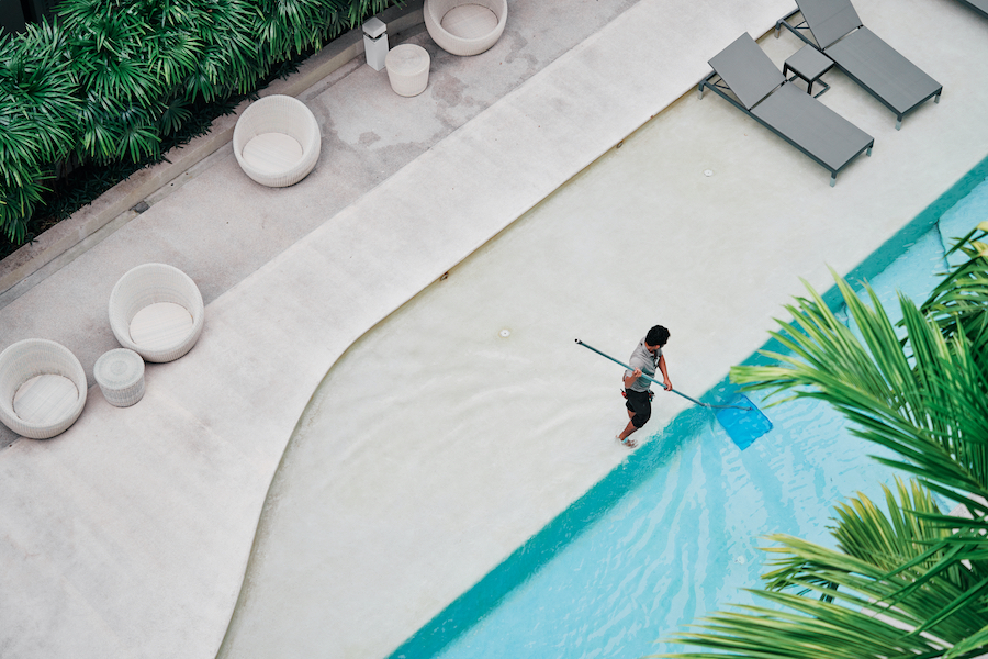 un homme en train de nettoyer une piscine