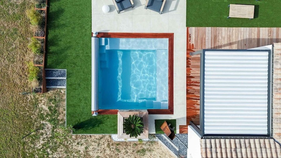 Bovenaanzicht van een vierkant zwembad met polyester kuip, geïntegreerd in een tuinmeubel