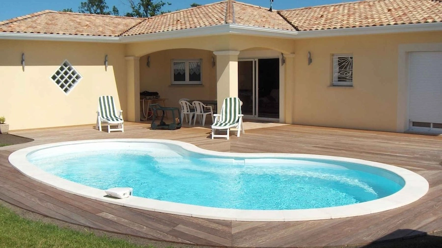 Uitzicht op een polyester zwembad in de vorm van een boon, ingebouwd in een houten terras