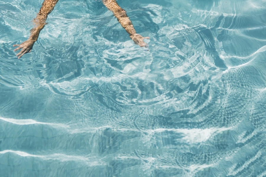 Baignade dans une piscine coque à l'eau turquoise, illustrant le volume d'eau d'un bassin